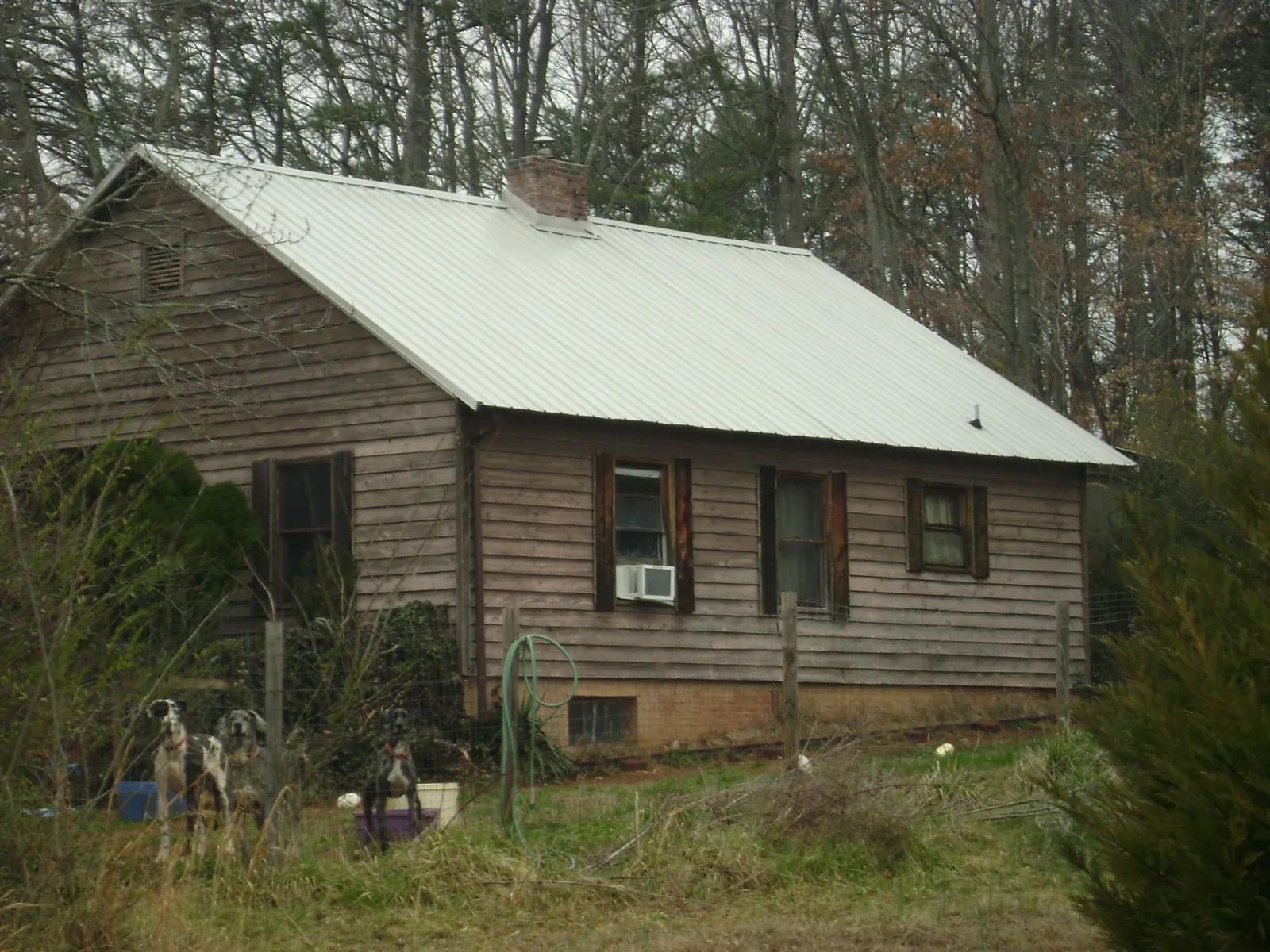 White metal roof on an old wood sided farmhouse, from a Asphalt Shingle Roof Repair job in Rolesville